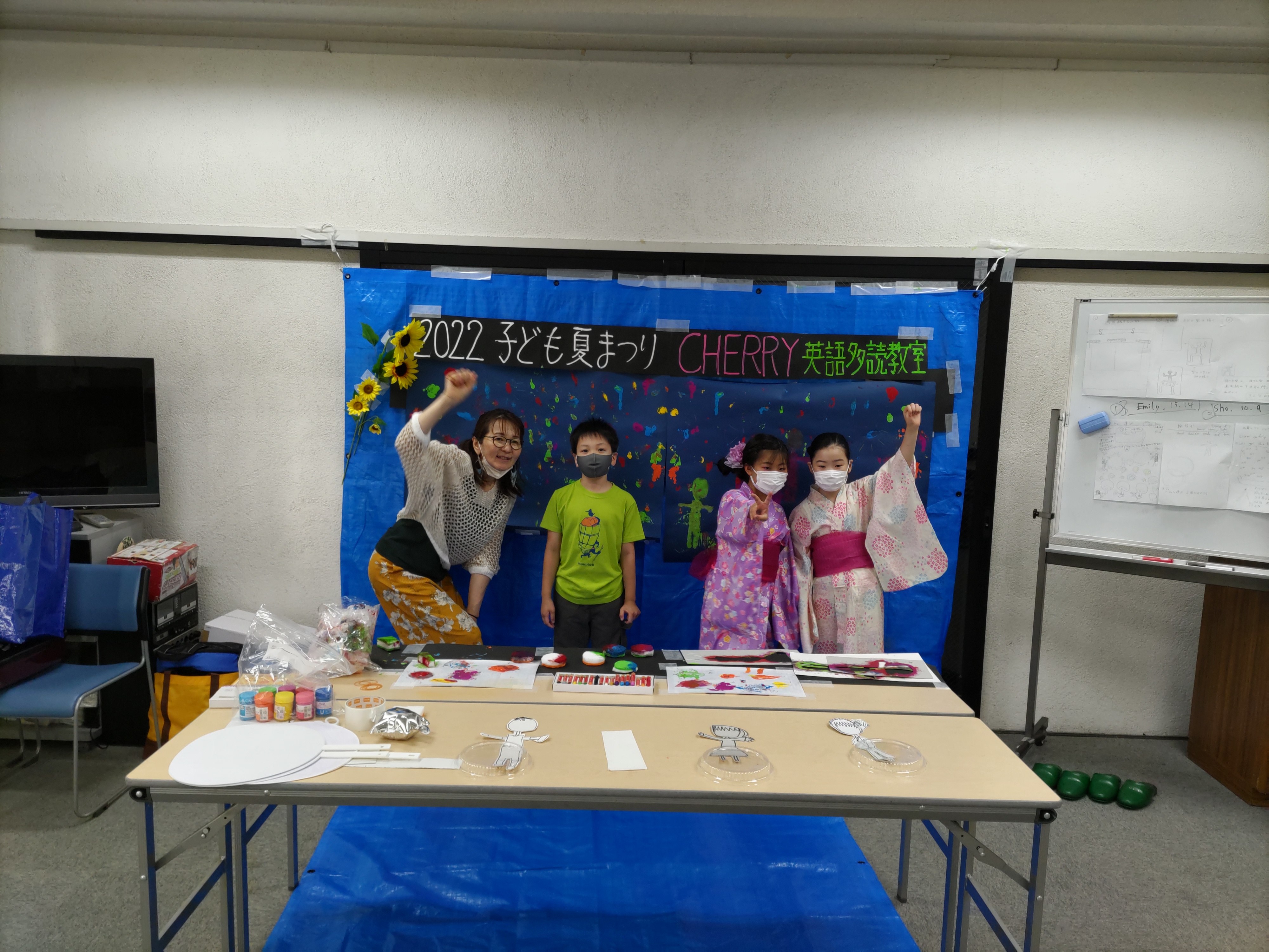 子ども夏祭りの展示の前に立つ講師と子どもたち