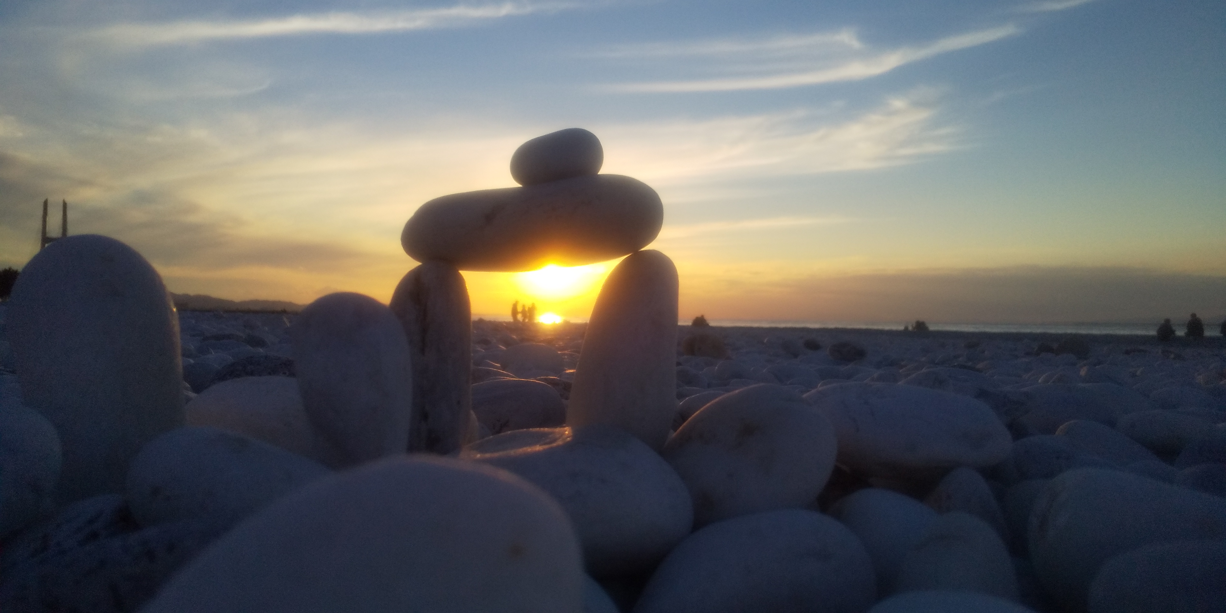 石のオブジェの向こうに沈む夕日