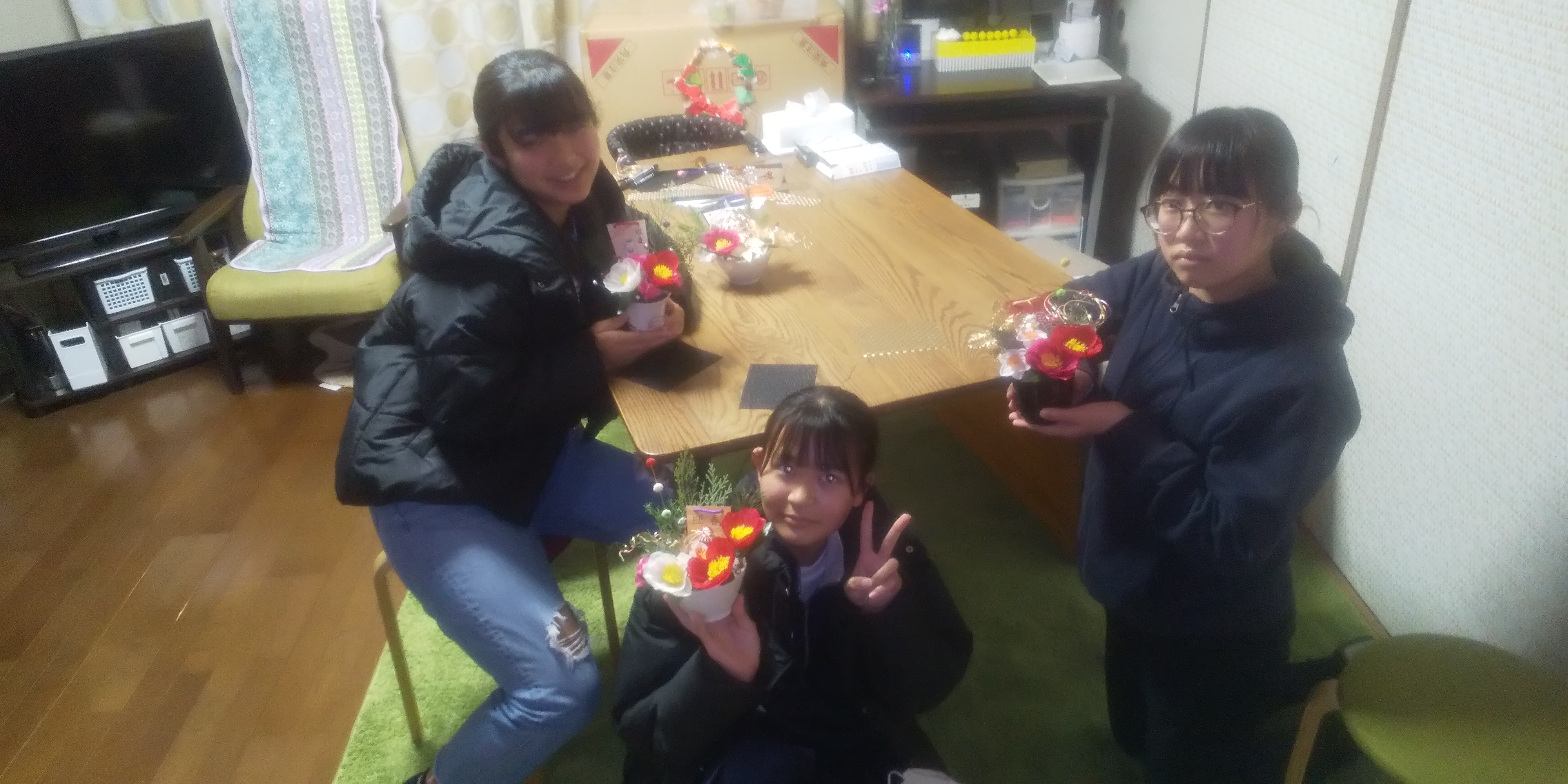 花飾りの作品を持つ生徒たち